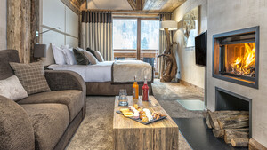 Chambre d'hôtel luxueuse avec cheminée allumée - Hôtel Luxe Alpes - Le Kaïla