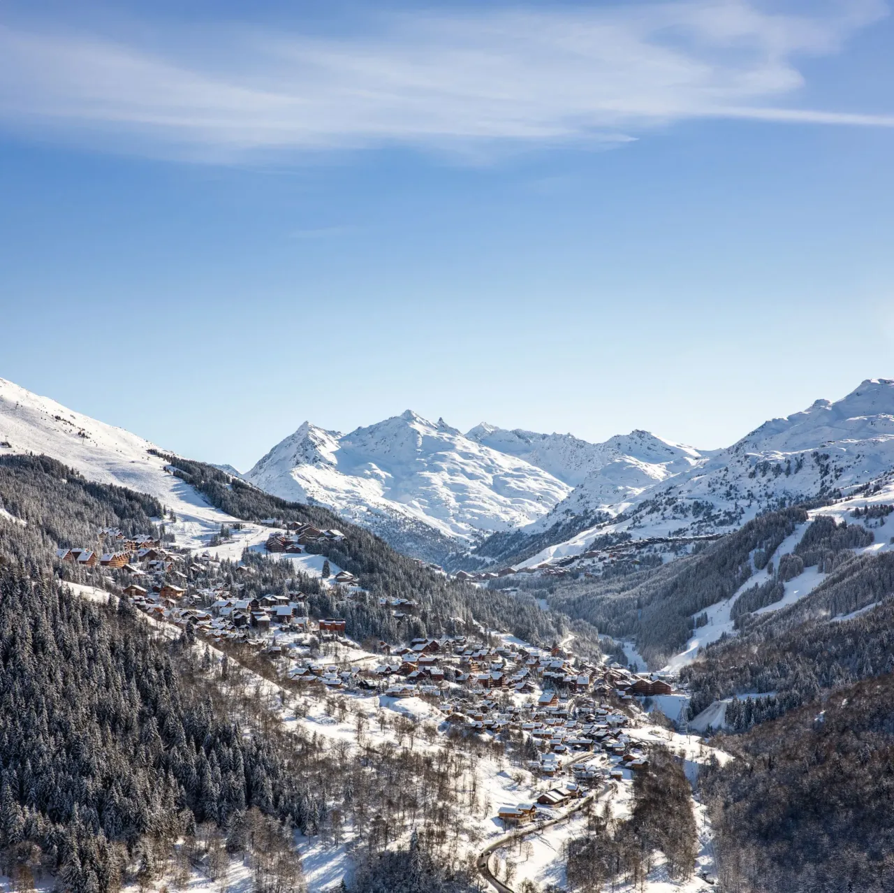 Village alpin enneigé avec montagnes en arrière-plan.